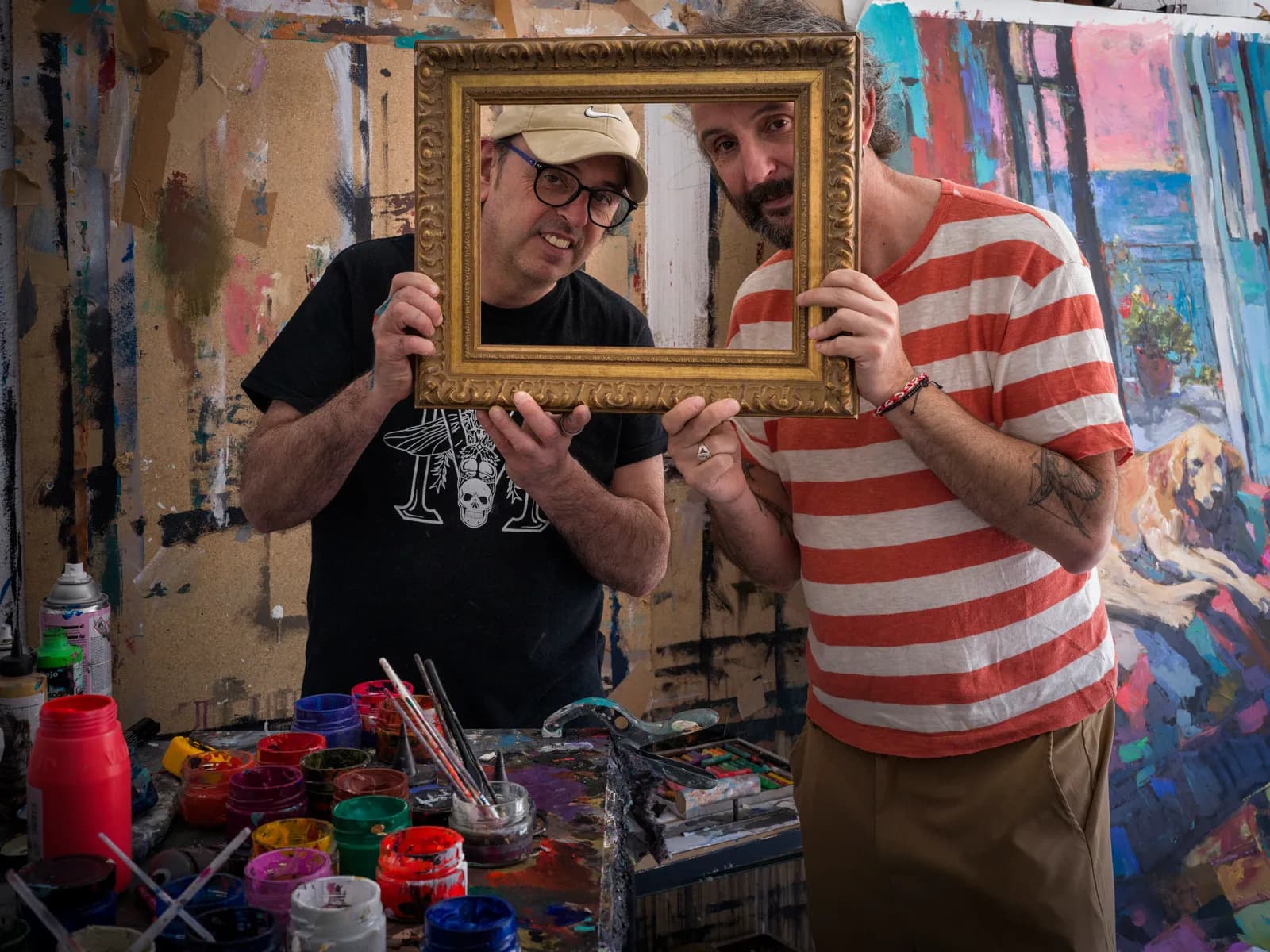 Grego and Raúl share a playful moment with a picture frame in the studio.